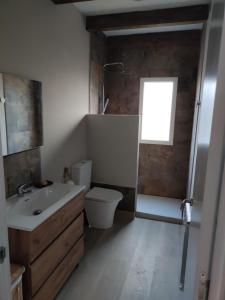 a bathroom with a sink and a toilet and a window at Cesarina Urban Rural House in Chantada