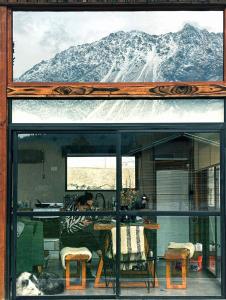 a woman sitting at a table with a mountain in the background at Rest in the mountains in El Bolsón