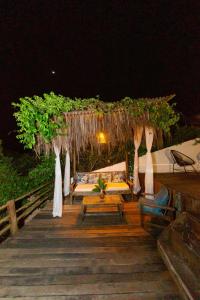 a wooden boardwalk with a seating area at night at Recanto do villa 2 in Trancoso
