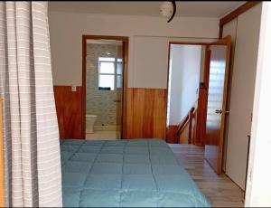 a bedroom with a bed and a door to a bathroom at Lomas San Andres in El Cerrillo