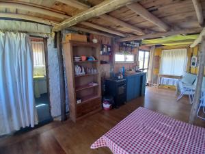 a living room with a table and a kitchen at El Rancho de Marcela in Cabo Polonio