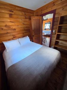 a bedroom with a white bed in a wooden room at Hunts Point 2-BR Coastal Retreat - Cottage # 1 in Summerville Centre