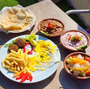 a table with a plate of food and bowls of food at Fifth Settlement Guest Rooms in New cairo