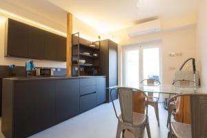 cocina con armarios negros y mesa de cristal en B&B Relax Rooms - Villa Segala, en Verona
