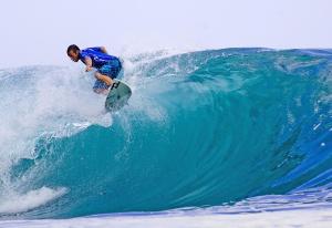 un homme faisant une vague sur une planche de surf dans l'océan dans l'établissement Apartment Qiu, à Costa da Caparica