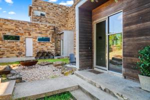 a brick house with a patio and a yard at Luxury 7BR Hill Country Gem Hot Tub & Barndominium in Dripping Springs +113 photos