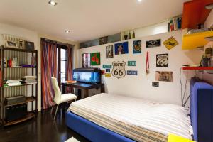 una camera con letto e scrivania con TV di Casa Mosaico a Palermo