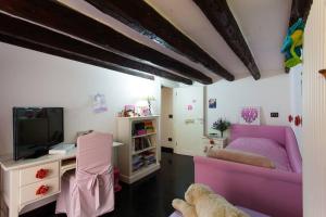 un soggiorno con divano rosa e TV di Casa Mosaico a Palermo