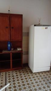 a kitchen with a white refrigerator and wooden cabinets at Departamento céntrico Belgrano in Reconquista