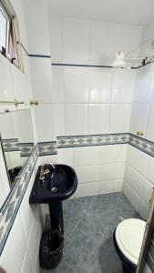 a bathroom with a toilet and a black sink at Caribe Palace Hotel Samambaia Sul in Brasilia +6 photos