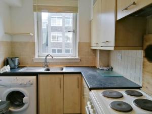a kitchen with a sink and a washing machine at City Centre Room in Glasgow