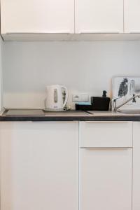 kuchnia z białymi szafkami i blatem w obiekcie Sopocki Dworek w mieście Sopot