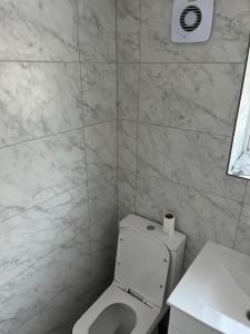 a white bathroom with a toilet and a sink at 65 Penn Crescent, Hayward Heath, Mid Sussex RH16 3HP in Moffat