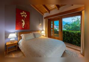 a bedroom with a bed and a large window at Love Nest Atitlán in Panajachel