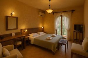 a bedroom with a bed and a desk and a television at Philoxenia in Kavala
