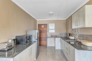 una cocina con nevera y microondas en Airville Luxury Apartments, 7min Drive to Cresta Mall, en Johannesburgo