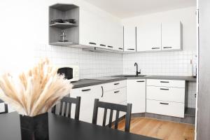 a kitchen with white cabinets and a table and chairs at Ferienglück Rosenheim in Rosenheim