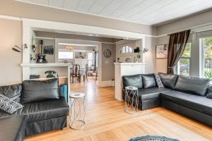a living room with a black couch and a kitchen at Miracle Mile Stay Classic Stockton Home with Yard! in Stockton