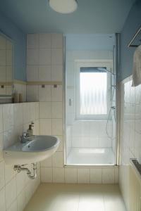 une salle de bain avec un lavabo et une douche dans l'établissement Küstenbutze Büsum, à Büsum