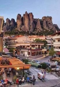 a group of people sitting at tables in front of a mountain at Meteora Grande luxury suite & spa villa in Kalabaka