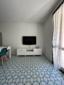 Una sala de estar con un televisor de pantalla plana y una mesa. en Casa Smeraldo, en Cavo 26 fotos más