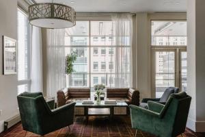 a living room with couches and a table and windows at Hotel Boutique at Grand Central in New York