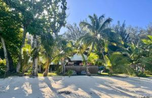 a house on the beach with palm trees at Fare One Island Moorea in Haapiti