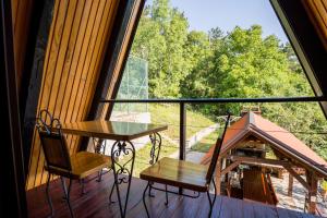 a balcony with a table and chairs and a large window at Little paradise house in Lič