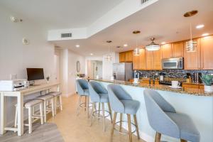 une cuisine avec un bar avec des tabourets de bar bleus dans l'établissement Condo with Views and Resort Amenities in Cape Harbour!, à Cape Coral