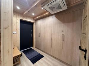 a room with wooden cabinets and a door at Mazurski Chill House in Małkinie
