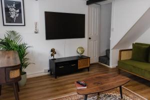 ein Wohnzimmer mit einem Flachbildfernseher an der Wand in der Unterkunft Old Castle Cottage Retreat in Oxford