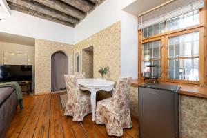 a living room with a table and chairs at 15th Century Flat with Parking, High Ceilings in Tallinn