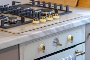 eine weiße Herdplatte mit goldenen Knöpfen darauf in der Unterkunft Old Castle Cottage Retreat in Oxford