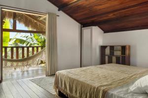 a bedroom with a bed and a large window at Pousada País Tropical in Icaraí