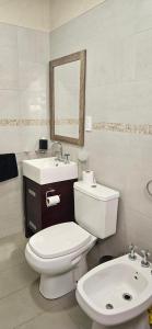 a bathroom with a white toilet and a sink at Entre Montañas - Vista Calma in Potrerillos