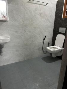 a bathroom with a toilet and a sink at Udupi Coral Homestay in Kalyānpur