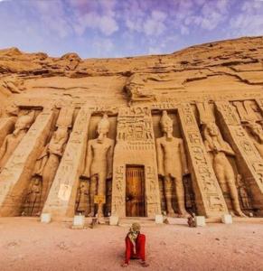 a person kneeling in front of an ancient building at Amon guest house in Abu Simbel