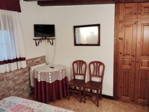 a room with a table and two chairs and a bedroom at Posada Le Dorat in Santillana del Mar