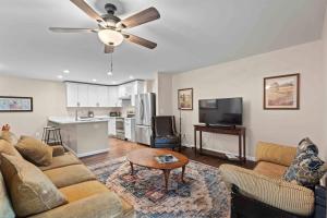 a living room with a couch and a ceiling fan at Stone's Throw by Mirror Lake in Highlands