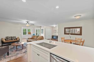 a kitchen with a sink and a living room at Stone's Throw by Mirror Lake in Highlands