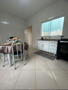 a kitchen with a table and chairs in a room at Elite na Serra in Cunha