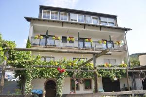 a building with a balcony with flowers on it at Hotel - Pension Wendland in Wintrich