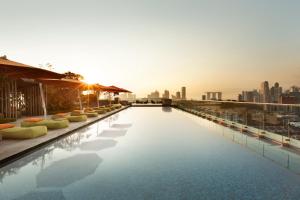a pool on the roof of a building with a city skyline at JEN Singapore Orchardgateway by Shangri-La in Singapore