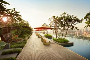 a wooden walkway with chairs and an umbrella on a building at JEN Singapore Orchardgateway by Shangri-La in Singapore