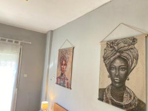 a painting of a woman hanging on a wall at Downtown Hostel AXD in Alexandroupoli