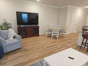 a living room with a television and a table and chairs at Brand new Townhouse in Orange Beach