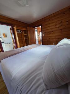 Cette chambre comprend un grand lit blanc. dans l'établissement Hunts Point 2-Bed Coastal Retreat - Cottage # 9, à Summerville Centre