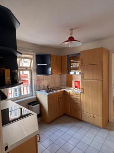 a kitchen with wooden cabinets and a sink at Voll ausgestattetes Apartment direkt in der City in Herrenberg +4 photos