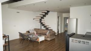 ein Wohnzimmer mit Sofa und Wendeltreppe in der Unterkunft Duplex Luxury Apartment in Berane