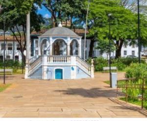 a large white building with a balcony in a park at Acomodação Bela Vista in Mariana